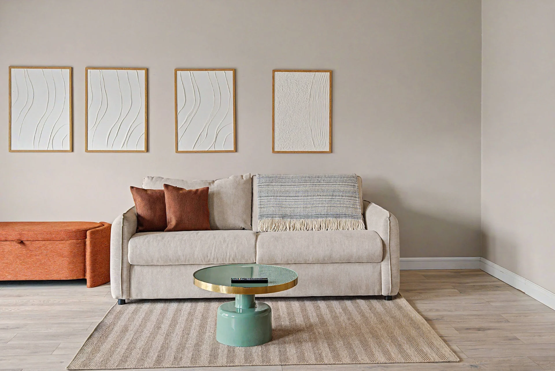 Wohnbereich mit Sofa, orangefarbenen Akzentkissen und gerahmter Wandkunst im Aparthotel-Apartment in Berlin — Interieurfotografie Immobilien