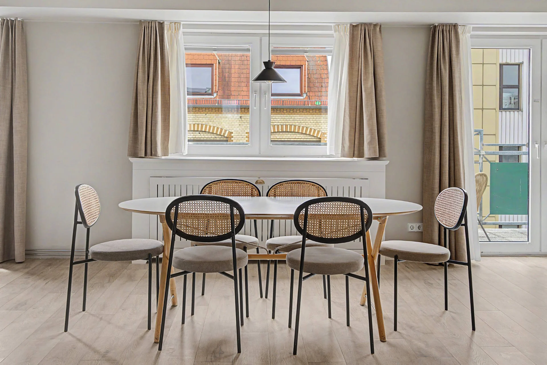 Heller Essbereich mit ovalen Tisch, Freischwinger-Stühlen und Fensterfront im Aparthotel-Apartment in Berlin — Innenaufnahme Immobilienfotografie