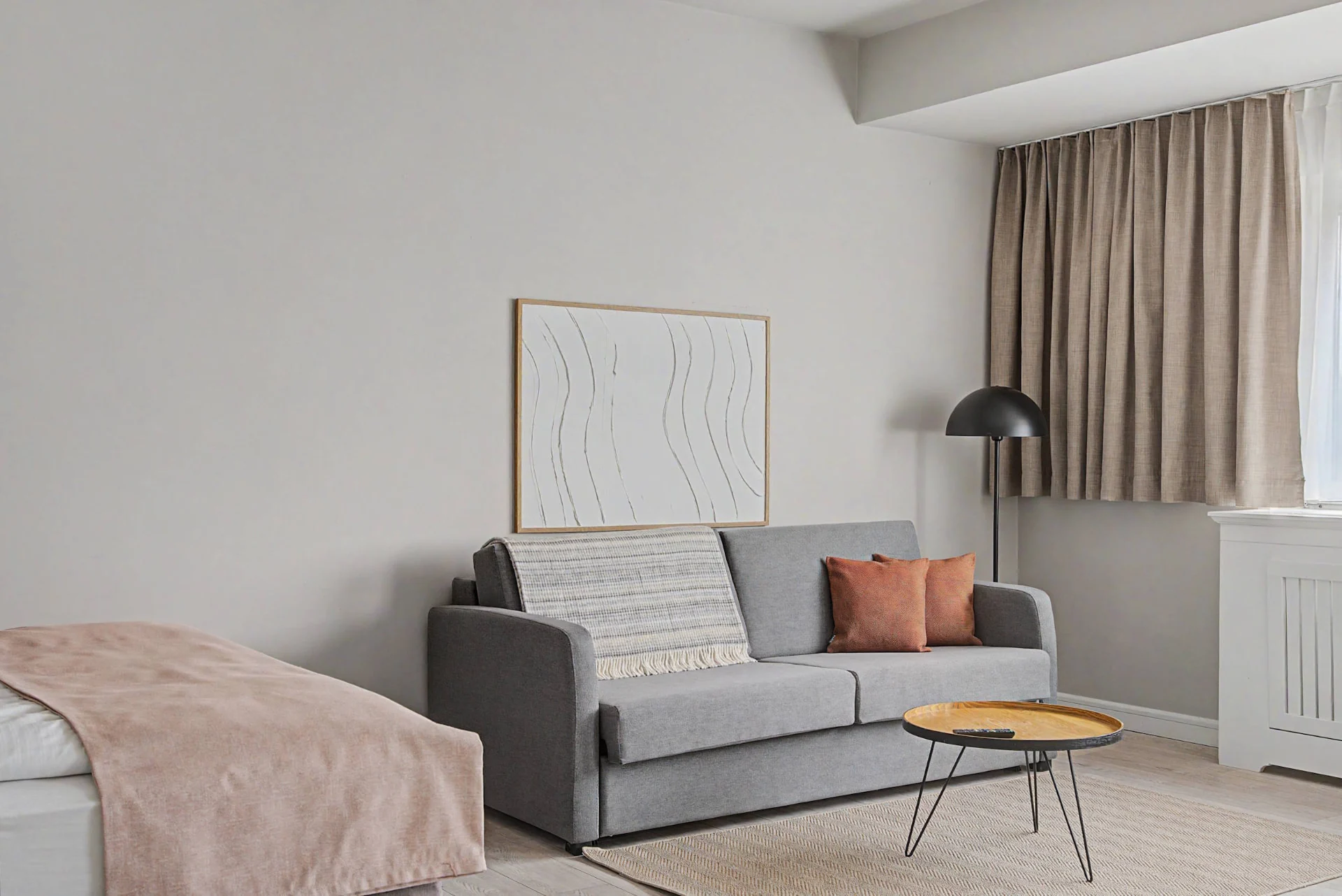 Kombinierter Schlaf- und Wohnbereich mit Bett, Sofa und Leselampe im Aparthotel-Apartment in Berlin — Interieurfotografie Immobilien